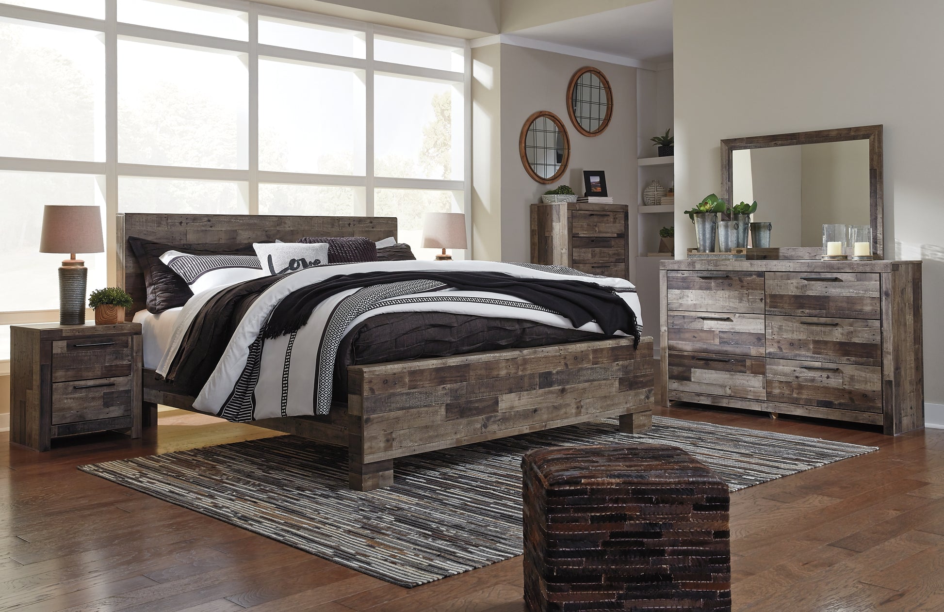 Derekson King Panel Bed with Mirrored Dresser, Chest and Nightstand - Premier Furniture & Mattress