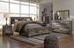 Derekson King Panel Bed with Mirrored Dresser, Chest and Nightstand - Premier Furniture & Mattress